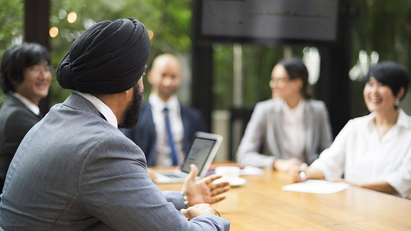 Five colleagues talking to each other during a business meeting.